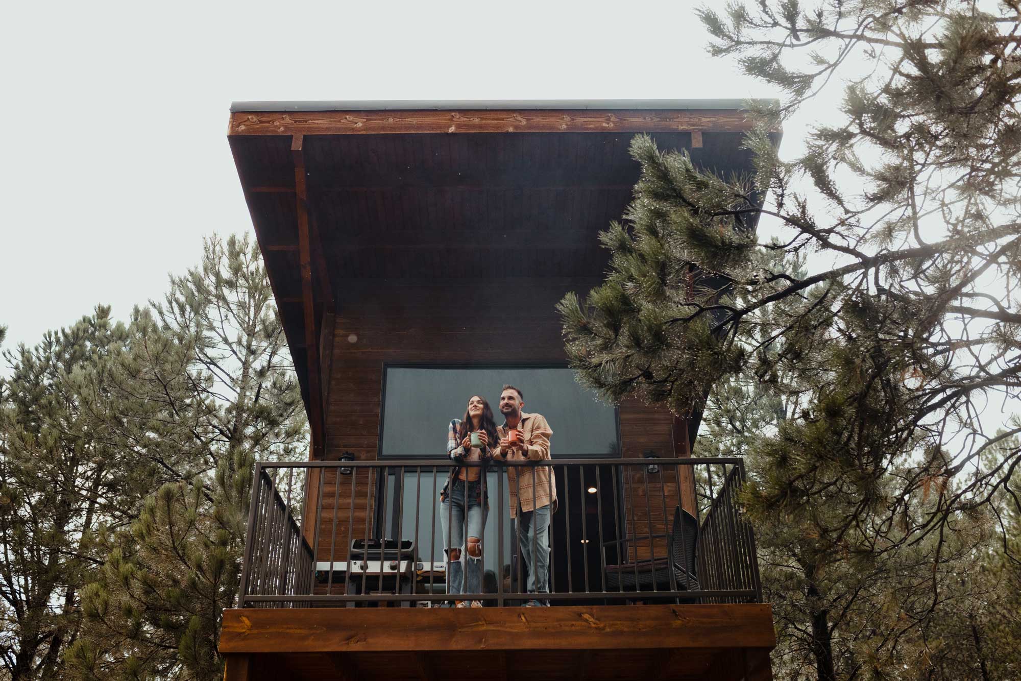 A couple stands on the balcony of a cabin in South Dakota